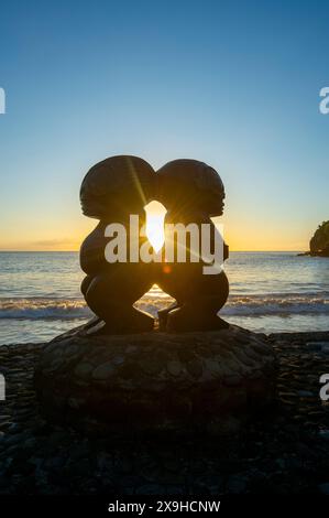 Aperçu de deux statues Tiki au coucher du soleil dans le petit village pittoresque d'Omoa, Fatu IVA, îles Marquises, Polynésie française Banque D'Images