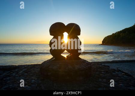 Aperçu de deux statues Tiki au coucher du soleil dans le petit village pittoresque d'Omoa, Fatu IVA, îles Marquises, Polynésie française Banque D'Images