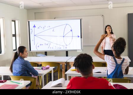 Jeune enseignante biraciale enseigne dans une salle de classe de lycée, avec espace de copie Banque D'Images