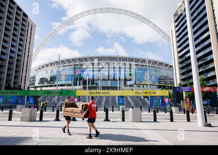 USAGE ÉDITORIAL EXCLUSIF Bradley Lemaire (à gauche) et Callum Barton (à droite) livrent un canapé appartenant aux vainqueurs de la compétition, Sarah carter et Mark Slaughter, au stade de Wembley à Londres, avant la finale de l'UEFA Champions League ce soir, dans le cadre de la compétition « No Walkers, No Game » des Walkers. Date d'émission : samedi 1er juin 2024. Banque D'Images