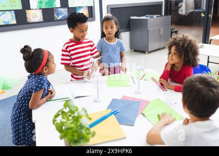 À l'école, divers jeunes élèves discutent de la durabilité en classe Banque D'Images