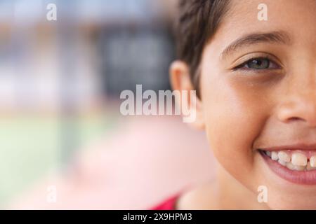 À l'école en plein air, jeune étudiant biracial souriant à la caméra avec un espace de copie Banque D'Images