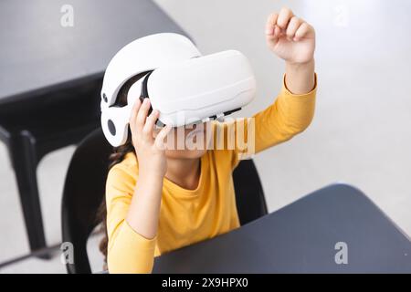 À l'école, jeune étudiante biraciale portant un casque VR dans la salle de classe Banque D'Images