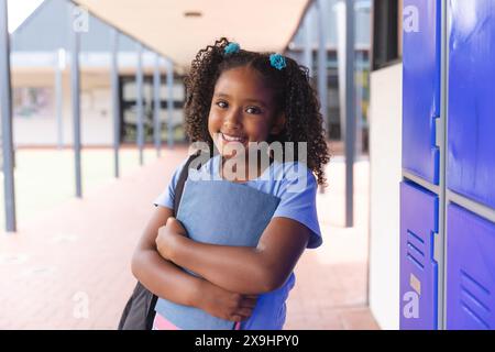 Fille biraciale se tient confiante à l'école Banque D'Images