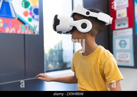Biracial Boy explore la réalité virtuelle à l'école Banque D'Images
