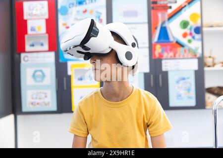 Biracial Boy explore la réalité virtuelle dans une salle de classe à l'école Banque D'Images