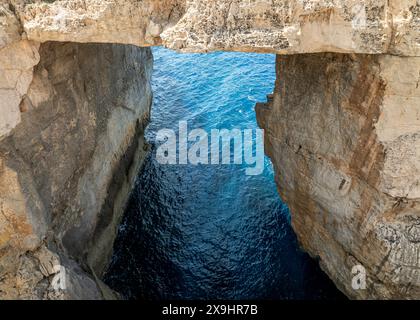 La fenêtre Wied il-Mielaħ est une arche calcaire naturelle sur la côte nord-ouest de Gozo. L'arche est située à l'extrémité de la vallée salée. Banque D'Images