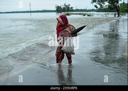 Sylhet, Bangladesh. 30 mai 2024. Les résidents âgés ont du mal à patauger sur la route principale inondée dans le quartier Lafnaut de Gowainghat upazila de Sylhet. Les pluies continues du cyclone Remal ont provoqué l'écoulement de l'eau des collines environnantes, submergeant la route depuis hier. Il est à noter que de nombreuses personnes ont quitté leur domicile et se sont rendues dans des refuges sûrs. Les zones basses et horifères de trois syndicats de l'upazila de Jaintapur à Sylhet sont inondées en raison de crues soudaines provoquées par de fortes pluies et de l'eau des pentes des collines. Environ 300 mille personnes dans quatre upazilas ont été piégées dans l'eau due Banque D'Images