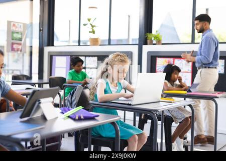 À l'école, groupe diversifié de jeunes étudiants se concentrant sur leurs études en classe Banque D'Images