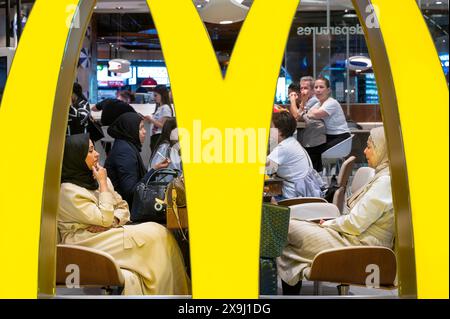 Les passagers des vols sont vus manger un repas dans la chaîne de restauration rapide américaine McDonald's à l'aéroport international de Dubaï, aux Émirats arabes Unis. Banque D'Images