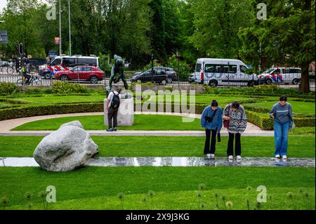 Trois femmes se rapprochent pour regarder une des sculptures. Pour sa première exposition personnelle aux pays-Bas, l’artiste coréen présente neuf œuvres emblématiques de la série Relatum, sur laquelle il travaille sans relâche depuis les années 70 Les sculptures en pierre et en métal entrent en dialogue avec la nature et l’architecture du bâtiment du musée. Lee Ufan (Corée 1936) travaille au Japon et en France. En plus des sculptures, il réalise également des peintures et est poète et philosophe. Avec ces sculptures, Lee Ufan expérimente ce qu'il décrit comme « l'art de la rencontre ». Les œuvres minimalistes offrent un Banque D'Images
