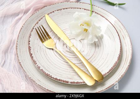 Cadre de table élégant avec belle fleur sur fond gris Banque D'Images