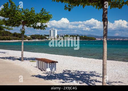 Vodice, Croatie, 24 mai 2024 : longue plage de galets dans la station balnéaire populaire de Vodice Banque D'Images