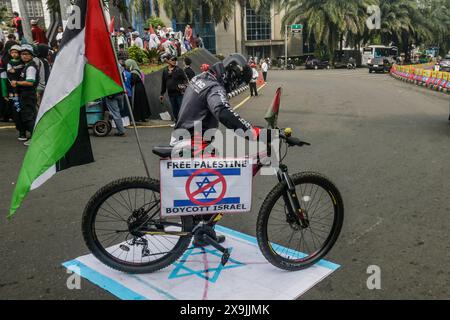 Des piétons marchent sur un drapeau israélien lors d’une manifestation pro-palestinienne « tous les yeux sur Rafah » à Bogor, Java occidental, Indonésie, le 1er juin 2024. Banque D'Images