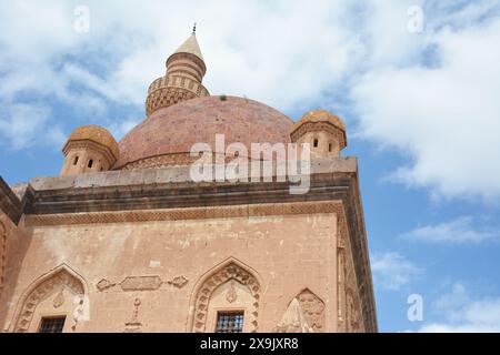 Ancien bâtiment islamique ou mosquée avec un dôme sur le dessus et versets arabes du Coran, sur fond de ciel bleu. palais ishak pacha à agri, turquie. Banque D'Images