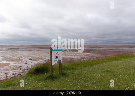 Un signe d'avertissement de sol instable / falaises, en raison de l'érosion côtière, le long de la côte de Mersea est, île de Mersea, Essex, Angleterre, Royaume-Uni. Banque D'Images