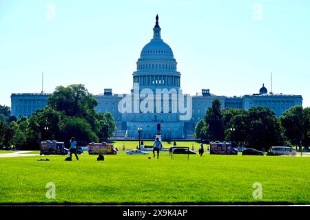 Washington, D.C., États-Unis - 1er juin 2024 : un homme et une femme profitent d'un samedi matin sur le National Mall avec le Capitole des États-Unis en toile de fond. Banque D'Images