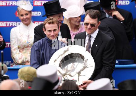 Le jockey Ryan Moore (à gauche) et l'entraîneur du cheval City of Troy, Aidan O'Brien, avec le trophée après la victoire au Derby de Betfred le jour du derby du Festival de Derby de Betfred à l'hippodrome d'Epsom Downs. Date de la photo : samedi 1er juin 2024. Banque D'Images