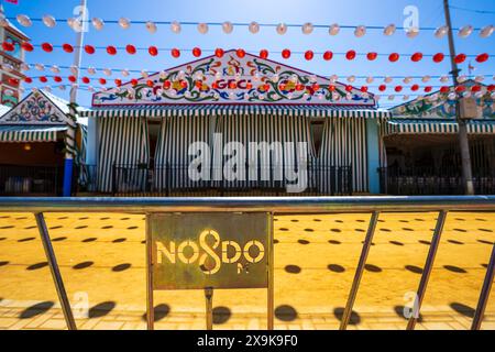 No8Do symbole de la ville au parc des expositions du festival de printemps pendant la Foire d'avril de Séville (Feria de Abril de Sevilla) avec des tentes de fête colorées (casetas), bannière Banque D'Images