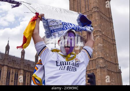 Londres, Royaume-Uni. 1er juin 2024. Un fan du Real Madrid tient un grand trophée en carton à côté de Big Ben avant la finale de la Ligue des Champions au stade de Wembley, alors que le Borussia Dortmund affronte le Real Madrid. Crédit : Vuk Valcic/Alamy Live News Banque D'Images