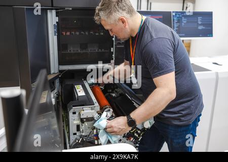 Ingénieur de maintenance dans une machine de fixation de maison d'impression Banque D'Images