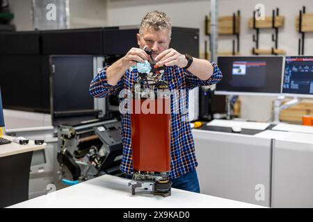 Ingénieur de maintenance dans une machine de fixation de maison d'impression Banque D'Images