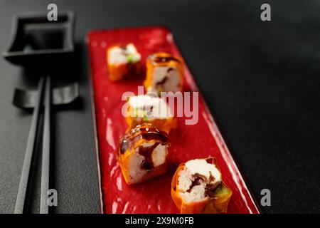 Cuisine japonaise : sushi, rouleau de Mami avec crabe des neiges. Fond noir Banque D'Images