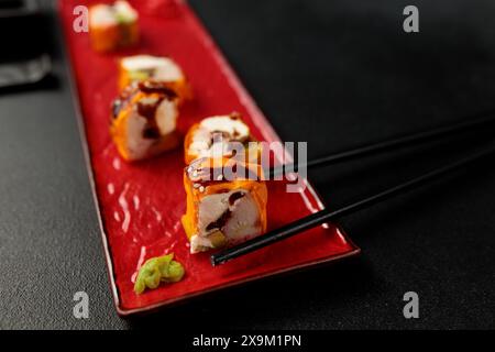 Un rouleau de Mami avec un crabe des neiges succulent est élégamment mis en valeur sur un fond noir, incarnant l'essence de la cuisine japonaise Banque D'Images