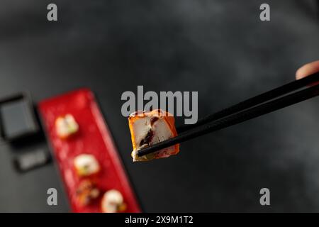 Un rouleau de Mami avec un crabe des neiges succulent est élégamment mis en valeur sur un fond noir, incarnant l'essence de la cuisine japonaise Banque D'Images