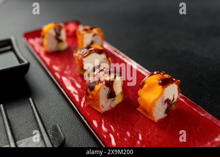 Un rouleau de Mami avec un crabe des neiges succulent est élégamment mis en valeur sur un fond noir, incarnant l'essence de la cuisine japonaise Banque D'Images