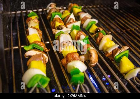 Brochettes d'ananas et de légumes sur le gril Banque D'Images