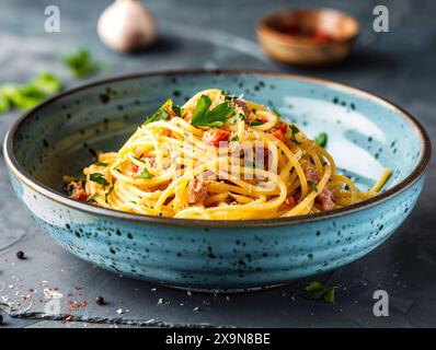 Spaghetti carbonara dans un bol en céramique moderne sur une table en ardoise sombre Banque D'Images