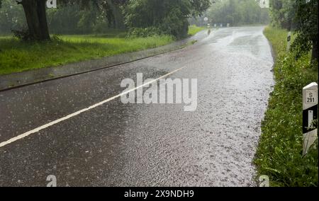 Rue inondée lors d'une tempête avec de fortes pluies dans le village Banque D'Images