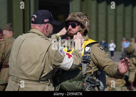 Les parachutistes à canopée ronde se préparent à charger sur un avion Douglas C47, connu sous le nom de Dakota, qui est devenu l'avion de transport le plus connu au monde et a été largement utilisé par les Alliés pendant la seconde Guerre mondiale lors de l'IWM Duxford Air Show dans le Cambridgeshire, alors qu'ils traversent la Manche pour continuer les commémorations du 80e anniversaire du jour J. Date de la photo : dimanche 2 juin 2024. Banque D'Images