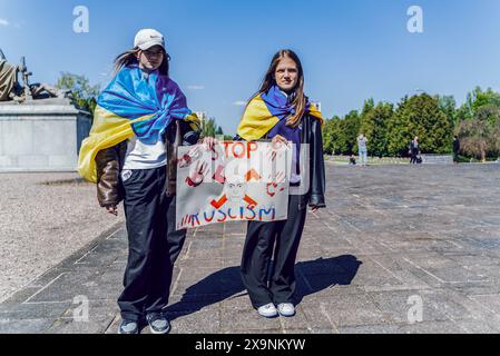 Varsovie, Pologne. 15 décembre 2022. Les manifestants avec des drapeaux ukrainiens accrochés sur le dos tiennent une pancarte disant ''arrêtez le ruscisme'' le jour de la victoire. Des militants ukrainiens manifestent devant le cimetière des soldats soviétiques. Les manifestants ont placé des maquettes de villes ukrainiennes détruites et des drapeaux ukrainiens symbolisant les Ukrainiens morts devant l'entrée du cimetière. La manifestation a eu lieu le jour de la victoire, le 9 mai 2023, à Varsovie. (Crédit image : © Marek Antoni Iwanczuk/SOPA images via ZUMA Press Wire) USAGE ÉDITORIAL SEULEMENT! Non destiné à UN USAGE commercial ! Banque D'Images