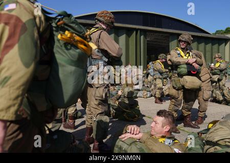 Les parachutistes à canopée ronde se préparent à charger sur un avion Douglas C47, connu sous le nom de Dakota, qui est devenu l'avion de transport le plus connu au monde et a été largement utilisé par les Alliés pendant la seconde Guerre mondiale lors de l'IWM Duxford Air Show dans le Cambridgeshire, alors qu'ils traversent la Manche pour continuer les commémorations du 80e anniversaire du jour J. Date de la photo : dimanche 2 juin 2024. Banque D'Images