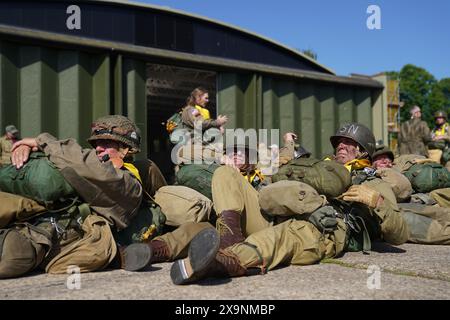 Les parachutistes à canopée ronde se préparent à charger sur un avion Douglas C47, connu sous le nom de Dakota, qui est devenu l'avion de transport le plus connu au monde et a été largement utilisé par les Alliés pendant la seconde Guerre mondiale lors de l'IWM Duxford Air Show dans le Cambridgeshire, alors qu'ils traversent la Manche pour continuer les commémorations du 80e anniversaire du jour J. Date de la photo : dimanche 2 juin 2024. Banque D'Images