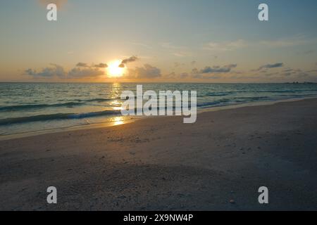 Vue grand angle de la plage Pass-a-grille dans le complexe Pete Beach Florida vers le nord-ouest. Large sable et vagues dans l'eau, près du coucher du soleil avec l'eau bleue Banque D'Images