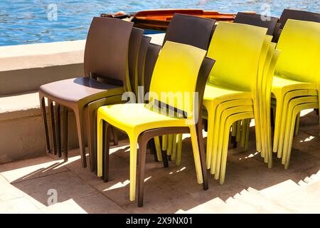 Chaises en plastique disposées en pile. Sièges de terrasse côtière Banque D'Images