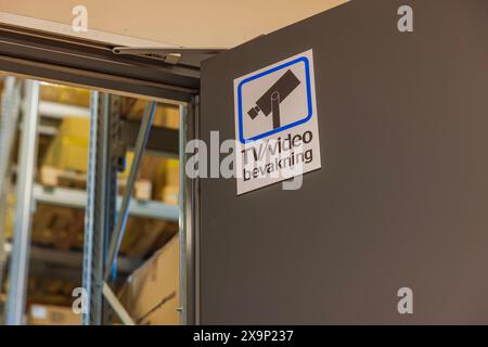 Vue rapprochée de l'installation industrielle avec le signe de surveillance sur la porte de l'entrepôt. Banque D'Images