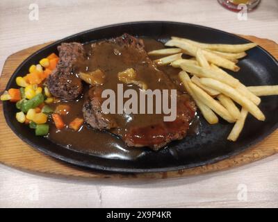 steak de boeuf mélangé avec des épices barbecue avec des pommes de terre frites et des légumes de carotte arachide Banque D'Images