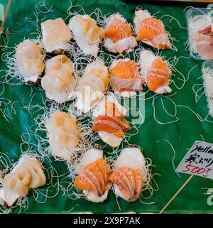 Variété de pièces de sushi disposées soigneusement sur un étal de marché, présentées à la vente Banque D'Images