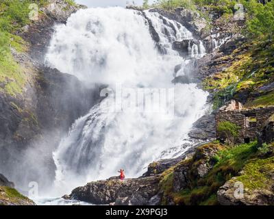 Femme dansant devant la cascade de Kjosfossen en Norvège Banque D'Images