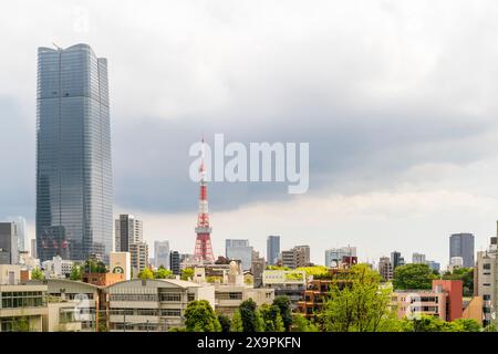 Azabudai Hills Mori JP Tower à côté de l'emblématique tour rouge et blanche de Tokyo sur les gratte-ciel de Tokyo lors d'une journée couverte vue depuis les collines de Roppongi. Banque D'Images