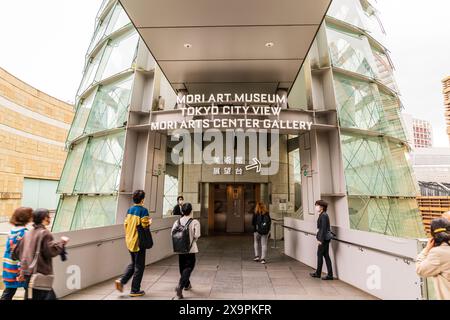 Les gens marchent vers et entrent au musée d'art Mori et à l'entrée vue sur la ville de Tokyo au complexe Roppongi Hills. Un peu de flou de mouvement. Banque D'Images