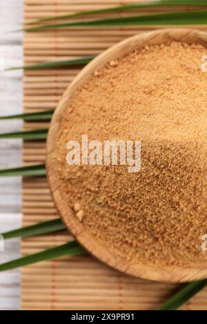 Sucre de noix de coco, feuilles de palmier et tapis de bambou sur la table, vue de dessus Banque D'Images