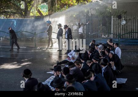 Bnei Brak, Israël. 02 juin 2024. La police israélienne utilise des canons à eau pour disperser les manifestants ultra-orthodoxes qui bloquent une route à Bnei Brak, lors d'une manifestation contre d'éventuels changements dans les lois exemptant les hommes ultra-orthodoxes de la conscription militaire. Crédit : Ilia Yefimovich/dpa/Alamy Live News Banque D'Images