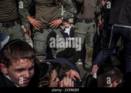 Bnei Brak, Israël. 02 juin 2024. La police israélienne intervient pour disperser les manifestants ultra-orthodoxes qui bloquent une route à Bnei Brak, lors d’une manifestation contre d’éventuels changements dans les lois exemptant les hommes ultra-orthodoxes de la conscription militaire. Crédit : Ilia Yefimovich/dpa/Alamy Live News Banque D'Images