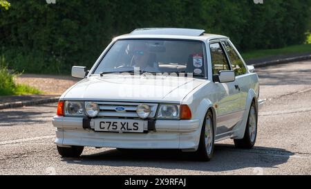Stoke Goldington, Royaume-Uni - 11 mai 2024 : 1986 Ford Escort rs turbo blanc conduisant sur une route britannique Banque D'Images