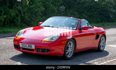 Stoke Goldington, Royaume-Uni - 11 mai 2024 : 2001 voiture rouge Porsche Boxster conduisant sur une route britannique Banque D'Images
